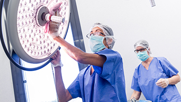 Two people cleaning an operating theatre in a hospital