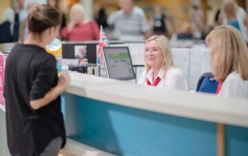 Receptionists talking to a woman