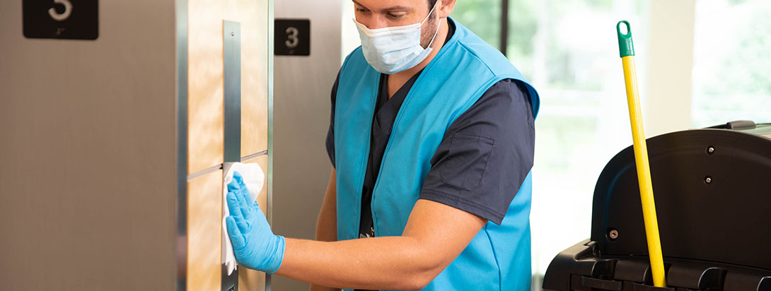 Man cleaning elevator buttons