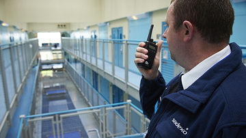 Prison officer speaking in to a walkie talkie